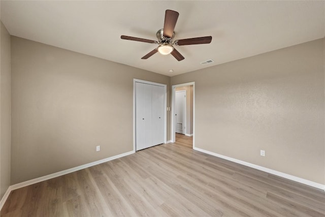 unfurnished bedroom featuring a closet, ceiling fan, and light wood-type flooring