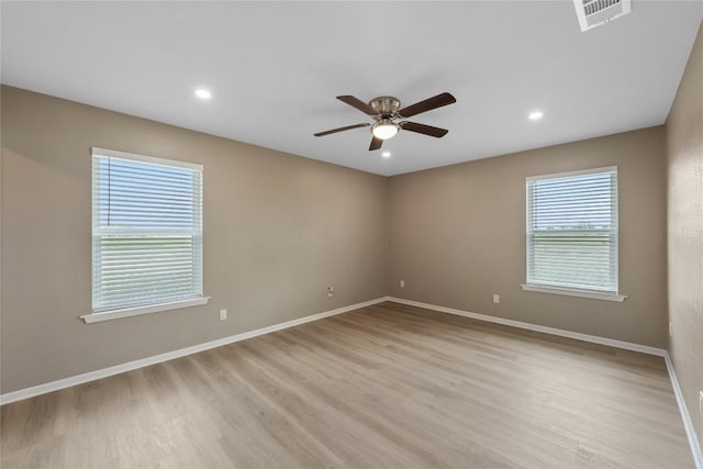 empty room with ceiling fan and light hardwood / wood-style flooring