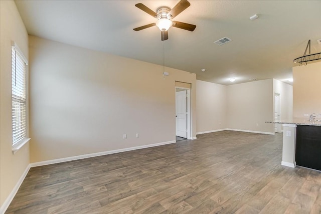 unfurnished living room with sink, dark wood-type flooring, and ceiling fan