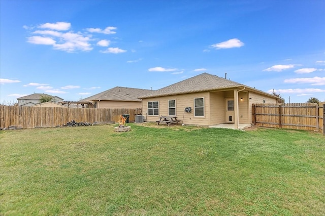 back of property with a patio, a yard, and central AC