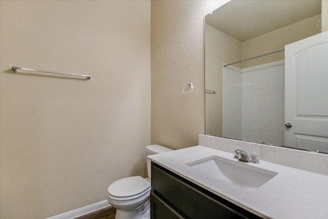 bathroom with walk in shower, vanity, and toilet