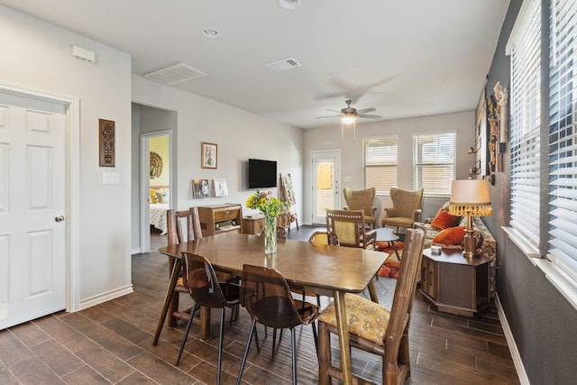 dining area featuring wood tiled floor, visible vents, ceiling fan, and baseboards