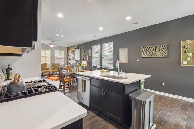 kitchen with dishwasher, sink, a wealth of natural light, and a kitchen island with sink