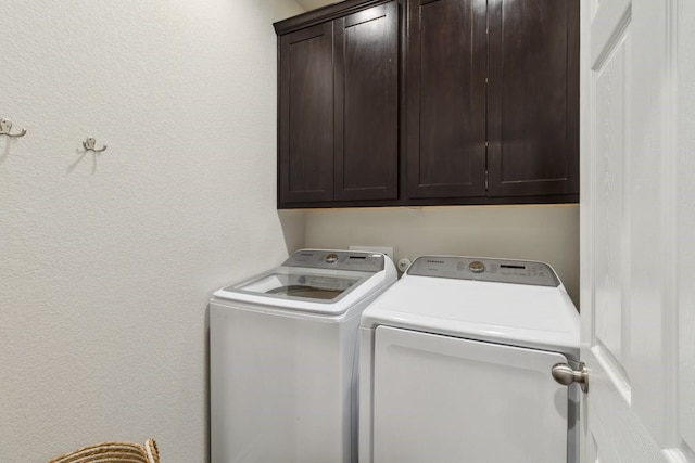 clothes washing area featuring cabinet space and independent washer and dryer