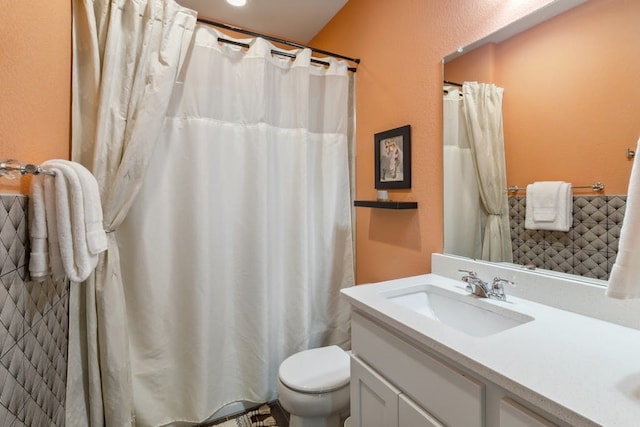 full bath with a shower with curtain, a textured wall, vanity, and toilet