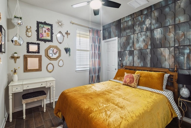 bedroom with visible vents, dark wood finished floors, baseboards, and ceiling fan