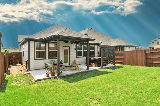 back of house featuring french doors, a patio, and a lawn