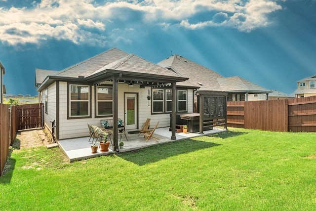 rear view of property with a lawn, a fenced backyard, roof with shingles, french doors, and a patio area