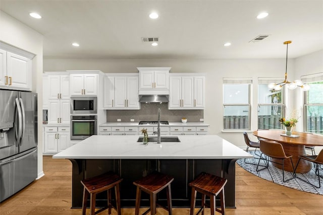 17408 Wildrye Dr, Austin, TX 78738 - kitchen featuring stainless steel appliances, light wood-style flooring, tasteful backsplash, white cabinetry, and recessed lighting
