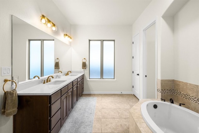 bathroom featuring vanity, tile patterned flooring, and a relaxing tiled tub