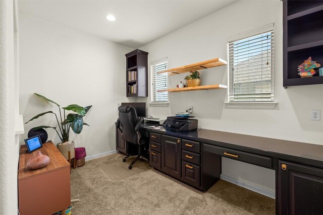 carpeted home office featuring built in desk