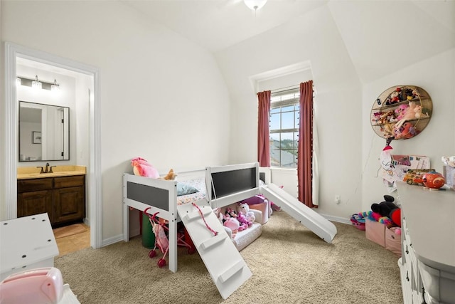 bedroom featuring light colored carpet, ensuite bathroom, and sink