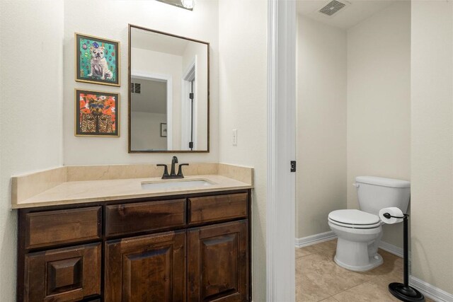 bathroom featuring vanity, tile patterned floors, and toilet