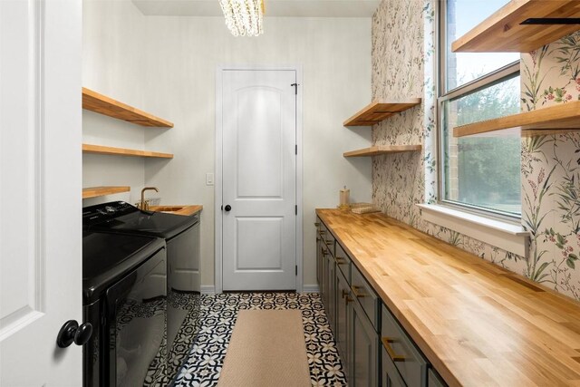 washroom with cabinets, independent washer and dryer, and sink