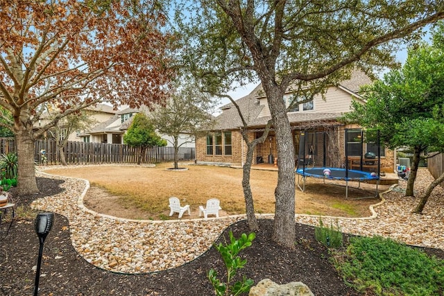 rear view of house featuring a trampoline