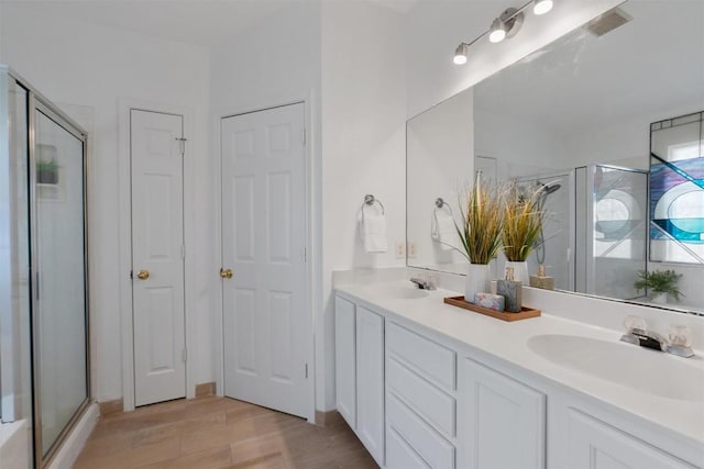 bathroom featuring vanity, an enclosed shower, and wood-type flooring