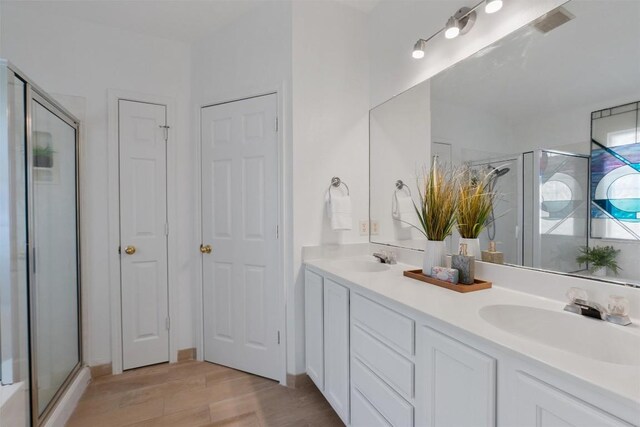 14420 Ballycastle Trl, Austin, TX 78717 - full bath with double vanity, a shower stall, wood finished floors, and a closet