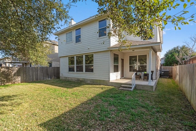 back of house with cooling unit, a yard, and a patio area