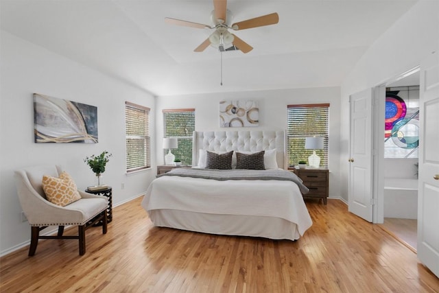 bedroom featuring a raised ceiling, ceiling fan, and light wood-type flooring