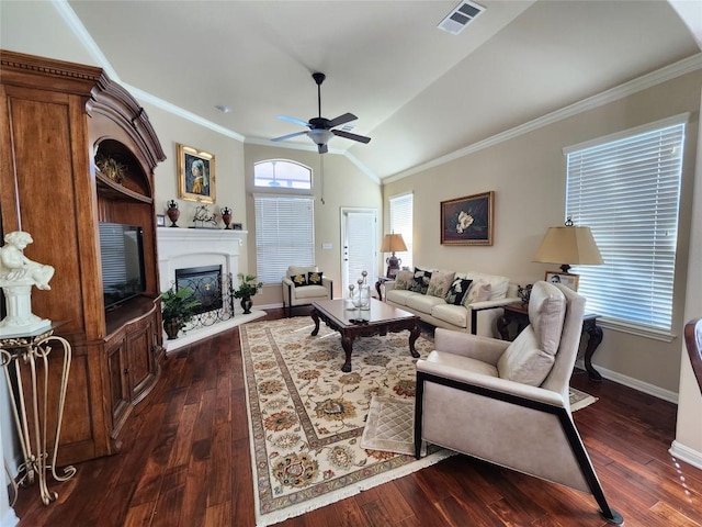 living room with baseboards, a fireplace with raised hearth, visible vents, dark wood finished floors, and crown molding