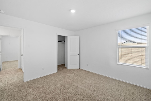 unfurnished bedroom with light carpet and a closet