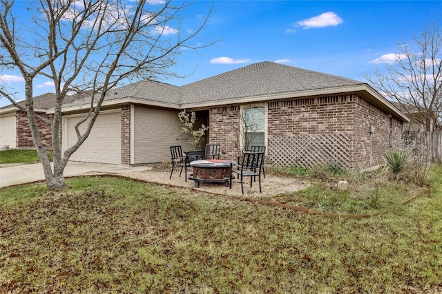 back of property featuring a fire pit, a yard, and a garage