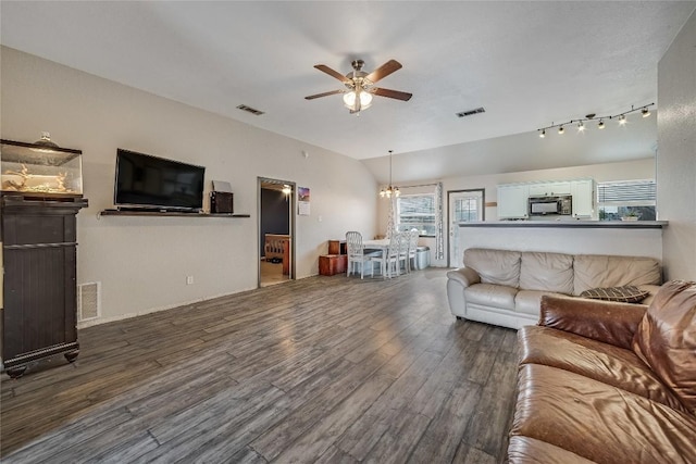 living room featuring lofted ceiling, hardwood / wood-style flooring, and ceiling fan with notable chandelier