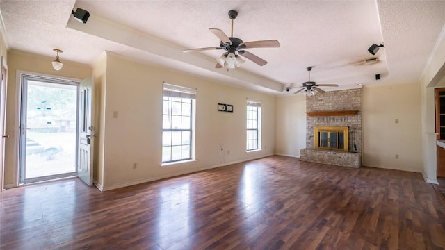 unfurnished living room with dark hardwood / wood-style floors, a raised ceiling, and a textured ceiling