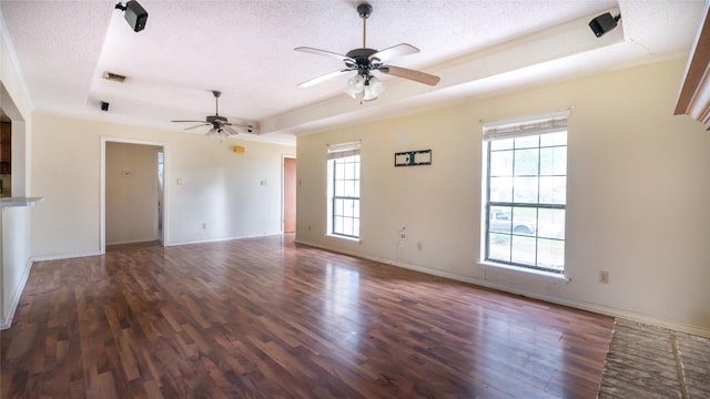 unfurnished living room featuring dark hardwood / wood-style flooring, a raised ceiling, and a textured ceiling