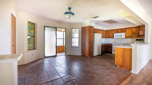 kitchen featuring white appliances, ornamental molding, kitchen peninsula, and a textured ceiling