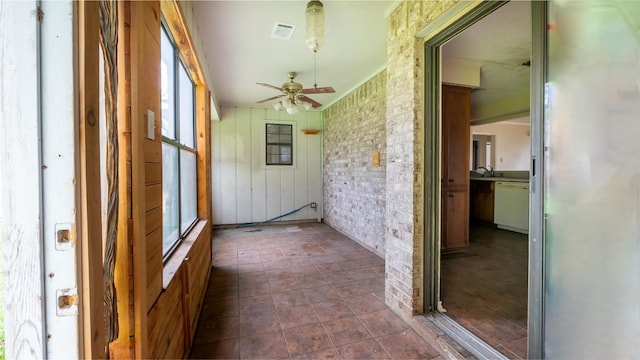 unfurnished sunroom with ceiling fan