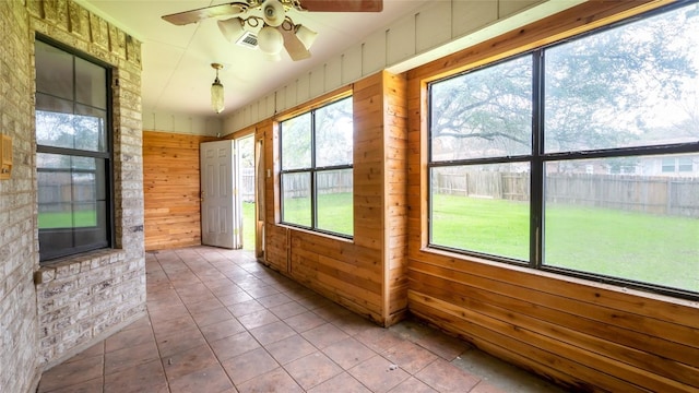 unfurnished sunroom with ceiling fan