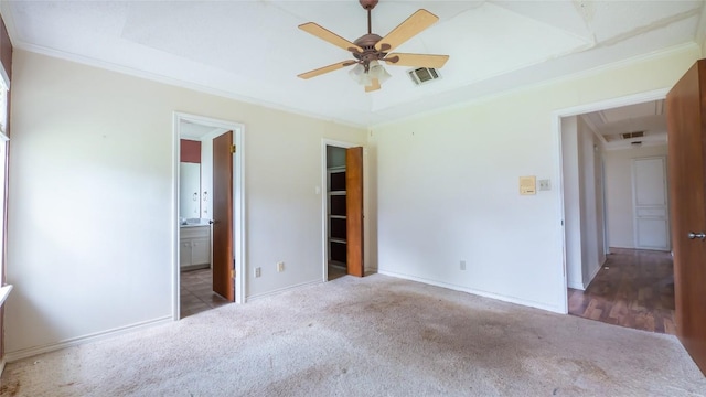 unfurnished bedroom featuring crown molding, carpet floors, ensuite bathroom, and a tray ceiling