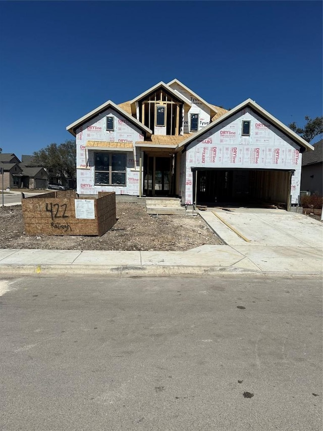 unfinished property featuring a garage and concrete driveway