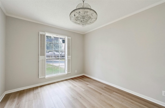 spare room featuring ornamental molding, a textured ceiling, and light wood-type flooring