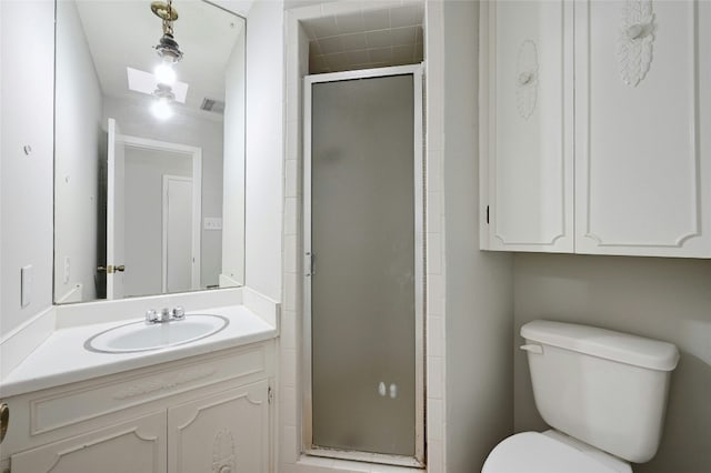 bathroom featuring vanity, a shower with shower door, and toilet