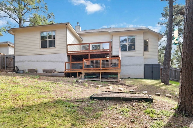 rear view of property with a wooden deck and a yard