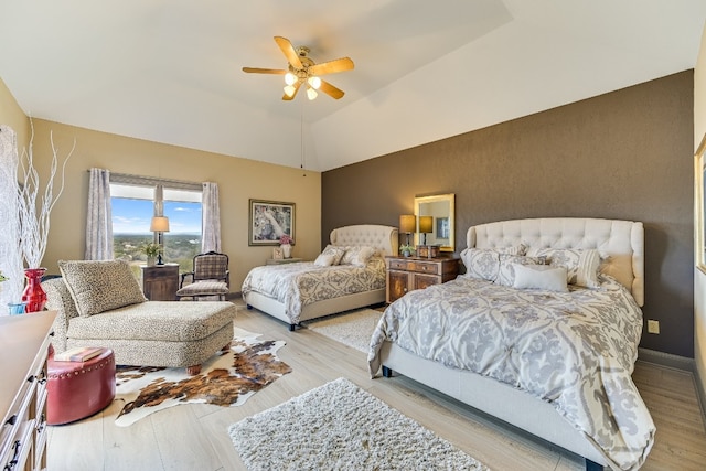 bedroom featuring light hardwood / wood-style flooring, ceiling fan, and vaulted ceiling