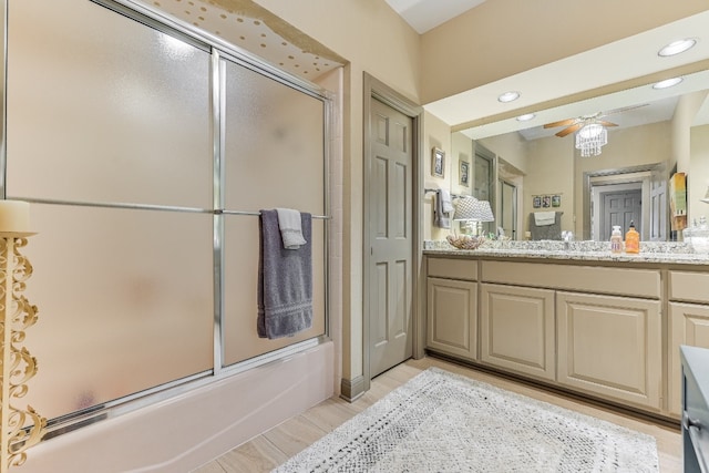 bathroom featuring ceiling fan, enclosed tub / shower combo, vanity, and hardwood / wood-style flooring