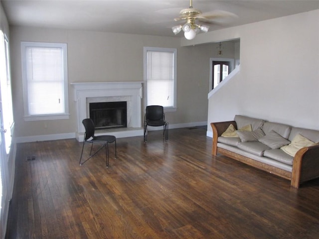 living area featuring ceiling fan, baseboards, wood finished floors, and a high end fireplace