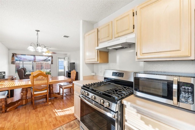 kitchen with pendant lighting, light hardwood / wood-style flooring, stainless steel appliances, a textured ceiling, and a chandelier