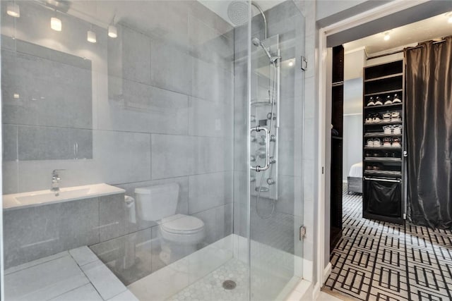 bathroom with toilet, tile walls, tile patterned floors, and walk in shower