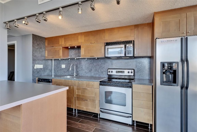 kitchen featuring tasteful backsplash, sink, a textured ceiling, and appliances with stainless steel finishes