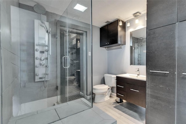 bathroom featuring vanity, an enclosed shower, and toilet