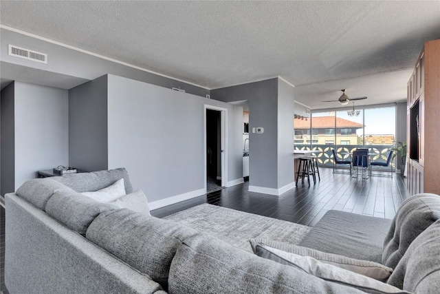 living room with ceiling fan, floor to ceiling windows, dark hardwood / wood-style floors, and a textured ceiling