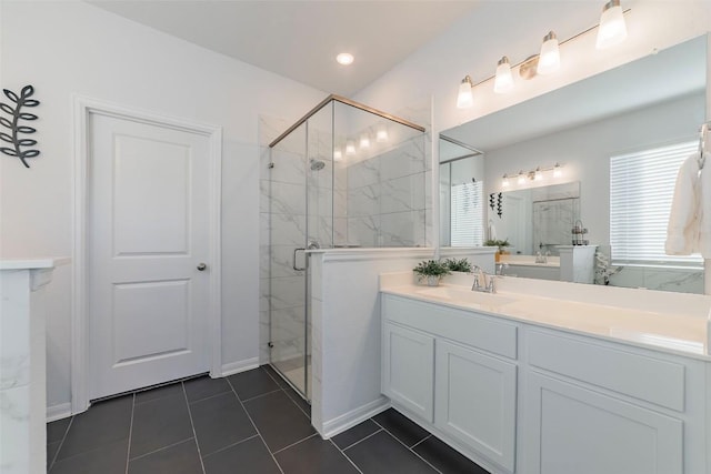 bathroom featuring a shower with door, vanity, and tile patterned floors