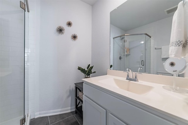 bathroom with tile patterned flooring, vanity, and walk in shower