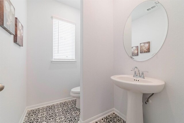 bathroom featuring sink, toilet, and tile patterned flooring