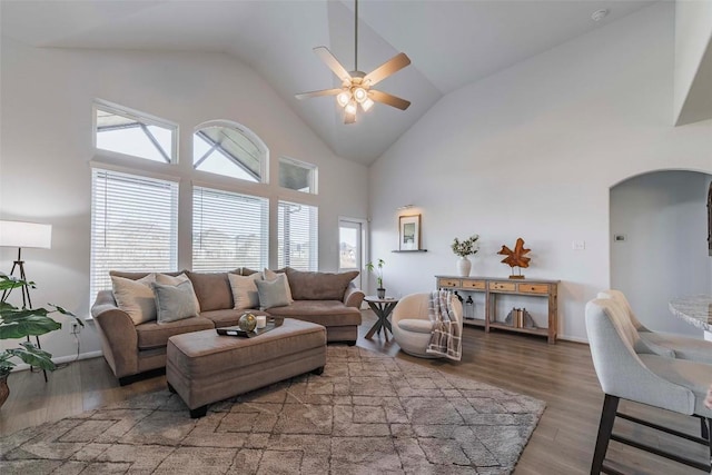 living room with ceiling fan, dark wood-type flooring, and high vaulted ceiling