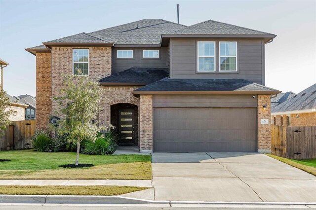 view of front of house featuring a garage and a front lawn